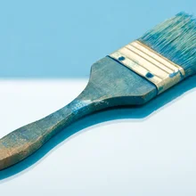 Blue paintbrush on two-tone blue background